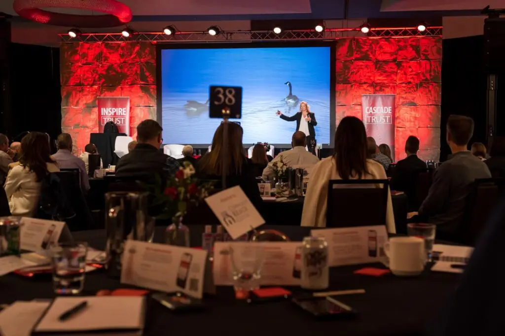 Conference presentation with audience and speaker.