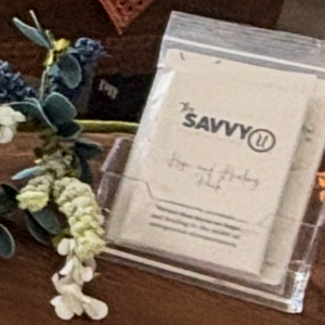 A framed quote about kindness with flowers nearby.