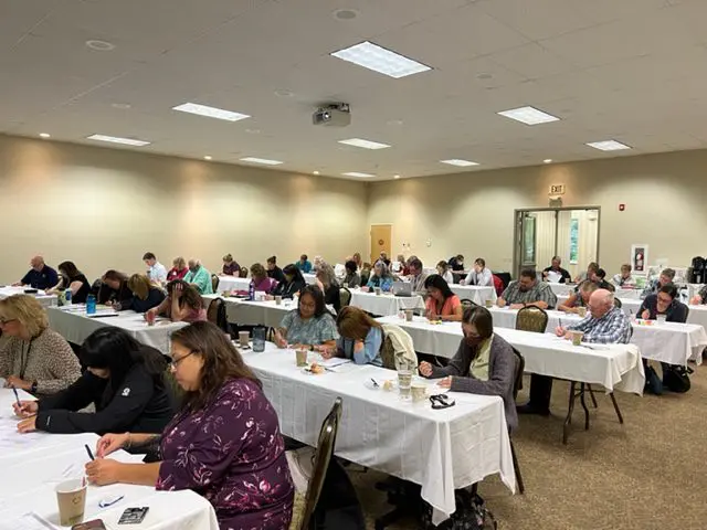 People attending a conference in a large room.