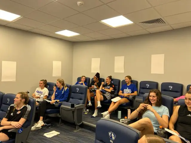 People sitting in a classroom, smiling.