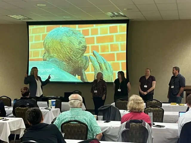 Presentation with four speakers and audience seated.