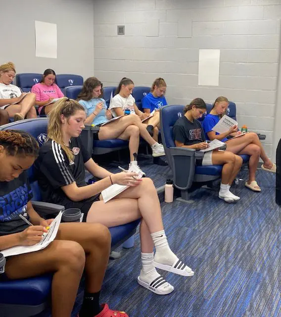 People in a room taking notes.