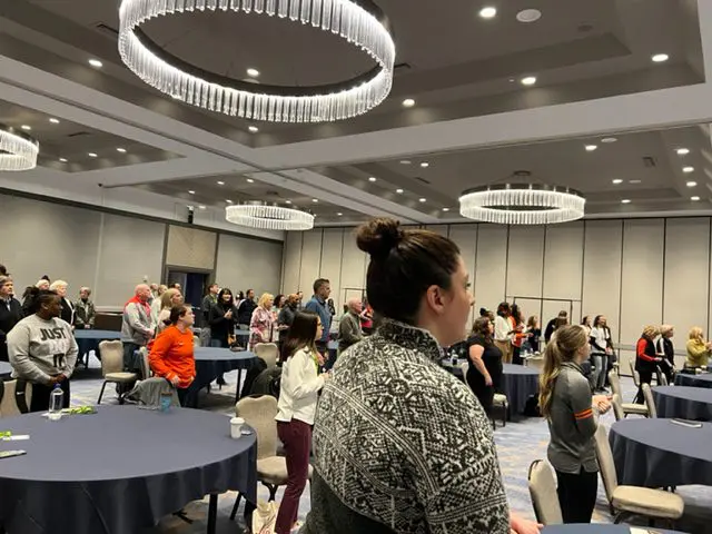 People standing in a conference room.