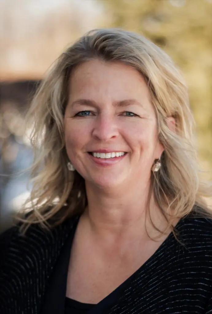 Smiling woman outdoors with blurred background.