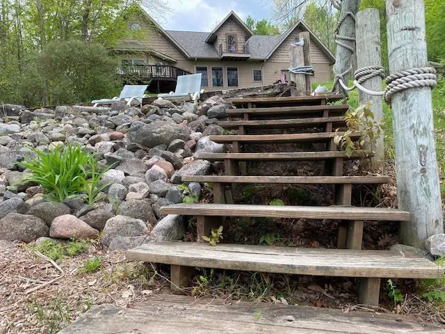 Wooden steps leading to a lakeside house.