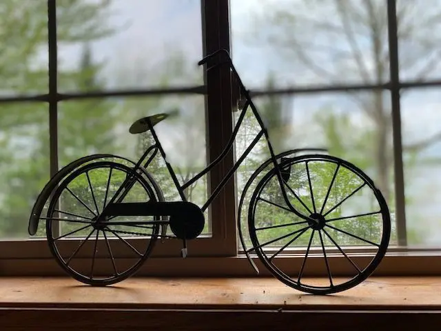 Metal bicycle model by a window.