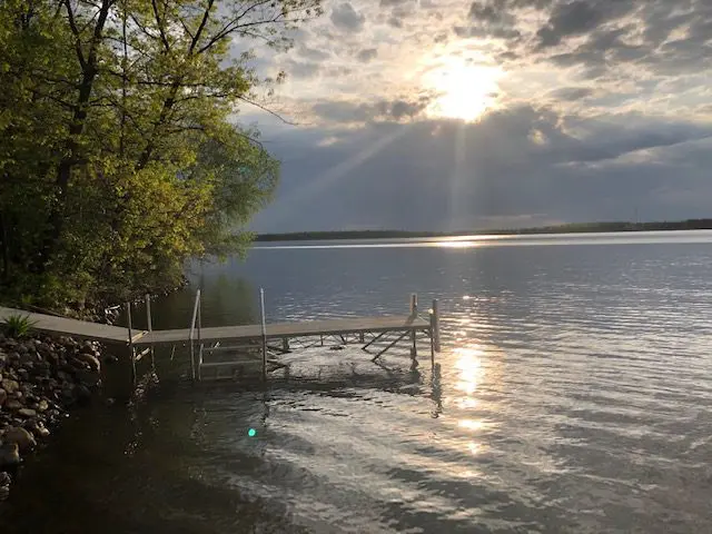 Sunset over lake with a wooden dock.