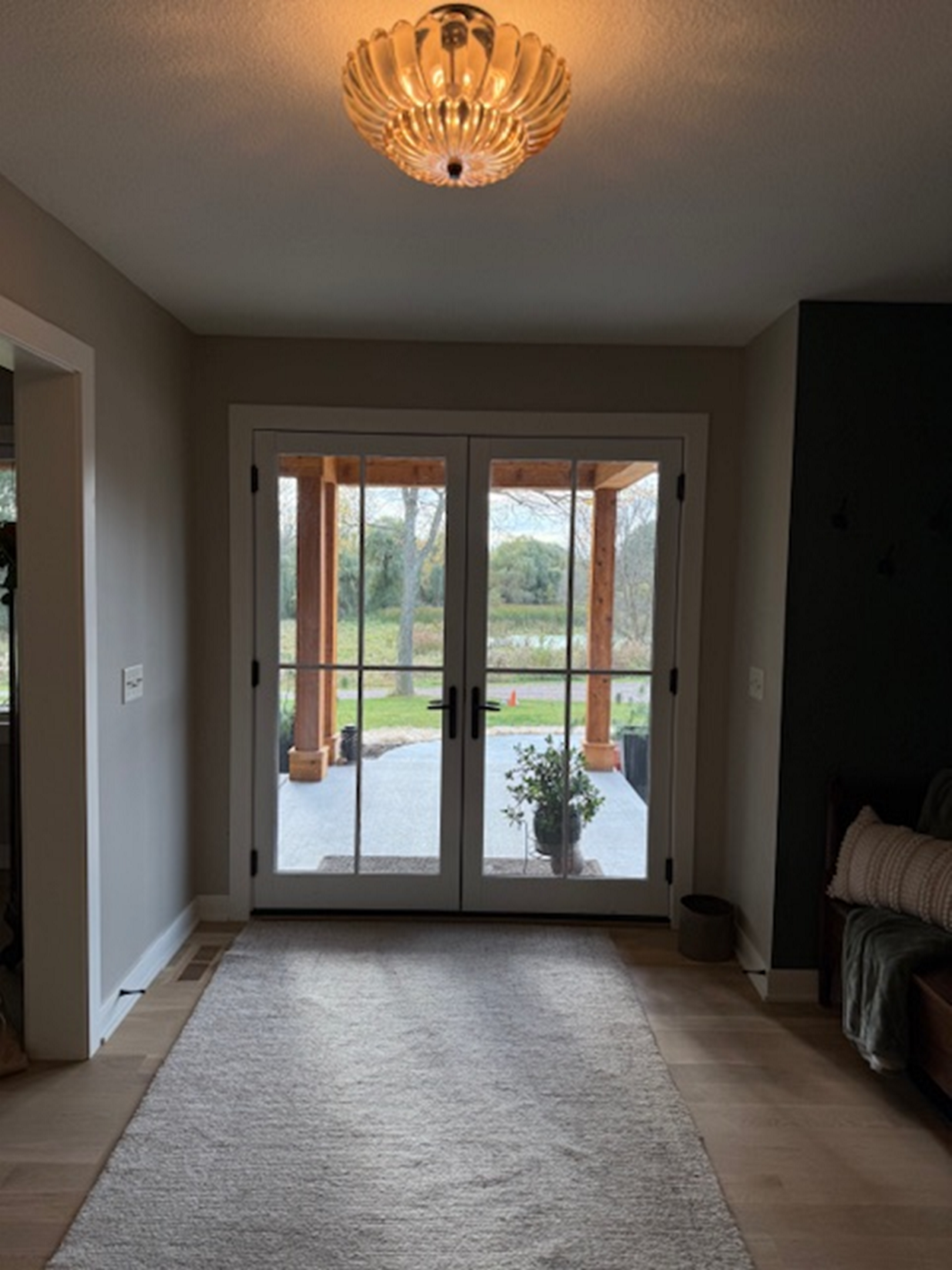 View through glass doors showing backyard and patio furniture.