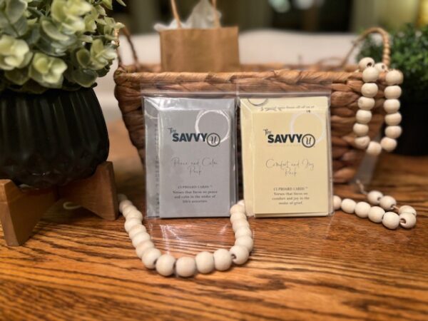 A wooden table with two bags of soap and a necklace.