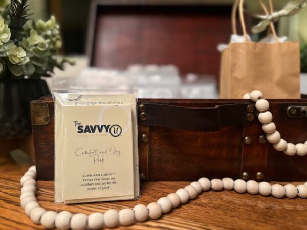 A wooden table with a bag and some beads