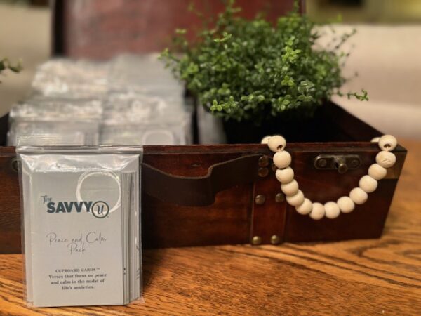 A wooden box with a white bead necklace on it.