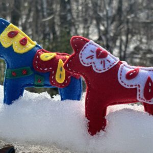 Two stuffed animals are sitting in the snow.